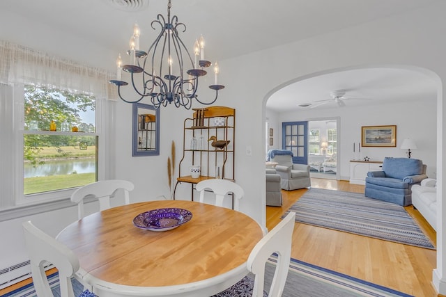 131 Henry Creek Ln, Kilmarnock, VA 22482 - dining space with arched walkways, light wood-style floors, a baseboard radiator, ceiling fan, and a chandelier