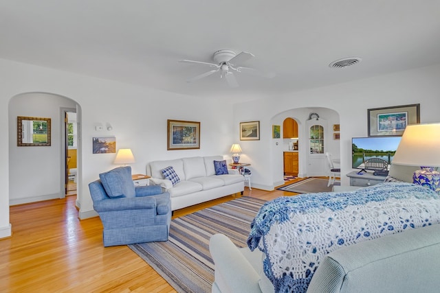 131 Henry Creek Ln, Kilmarnock, VA 22482 - living room with arched walkways, light wood-style floors, baseboards, a ceiling fan, and plenty of natural light