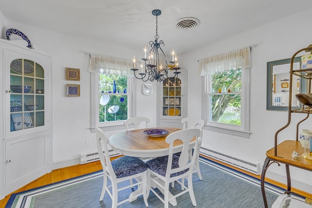 131 Henry Creek Ln, Kilmarnock, VA 22482 - dining area with wood finished floors, a baseboard radiator, a chandelier, and baseboards
