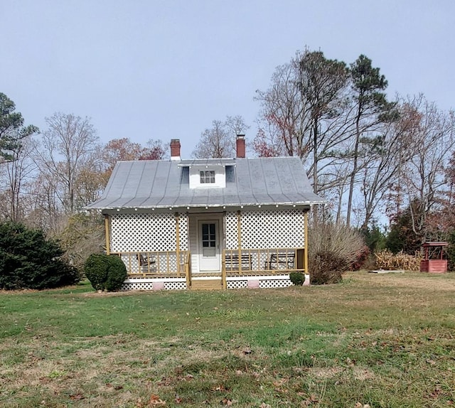 rear view of property featuring a lawn