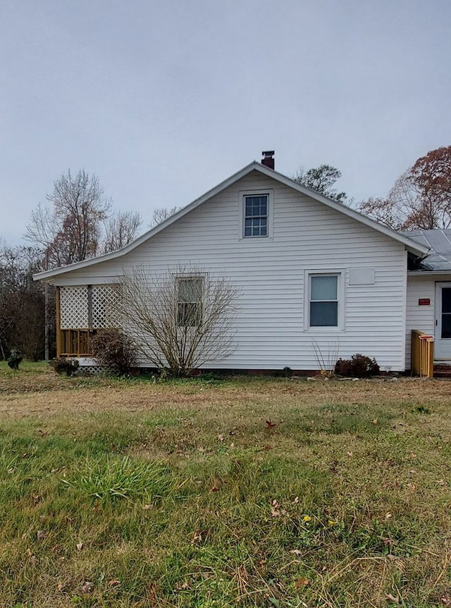 view of side of home with a yard