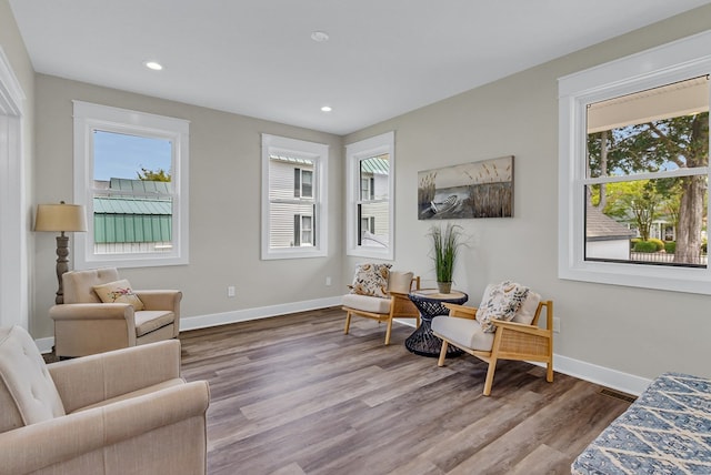 sitting room with plenty of natural light, baseboards, and wood finished floors