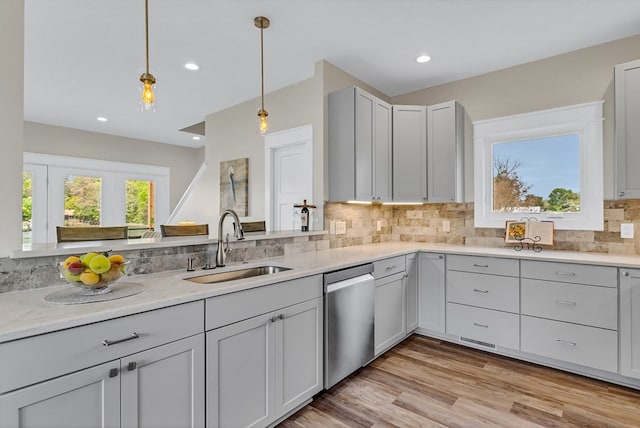 kitchen featuring recessed lighting, tasteful backsplash, a sink, dishwasher, and hanging light fixtures