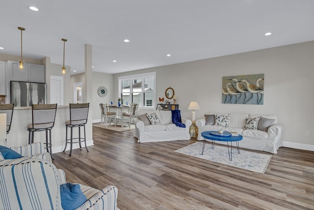 living area with recessed lighting, baseboards, and wood finished floors