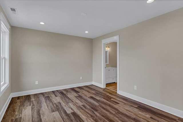 unfurnished room with visible vents, recessed lighting, baseboards, and dark wood-style floors