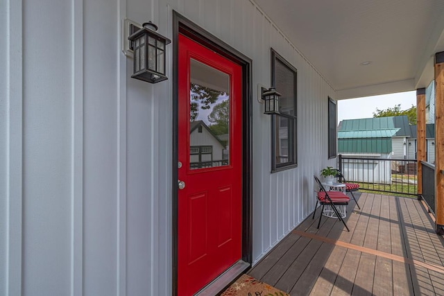 view of exterior entry featuring board and batten siding and covered porch