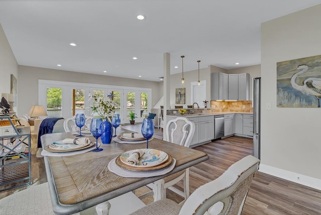 dining space featuring recessed lighting, baseboards, french doors, and light wood finished floors
