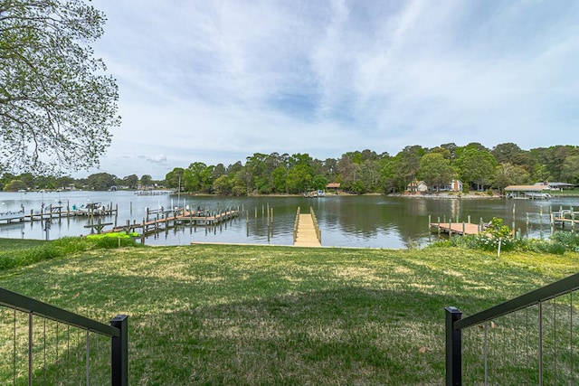 dock area with a lawn and a water view