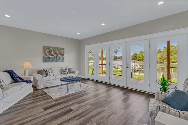living area with recessed lighting, baseboards, wood finished floors, and a healthy amount of sunlight