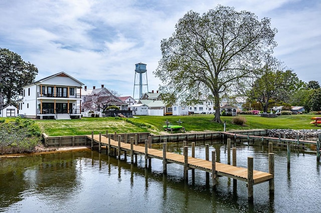 dock area featuring a lawn, a water view, and a balcony
