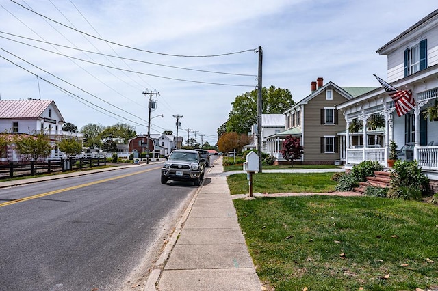 view of road with street lights, sidewalks, and curbs