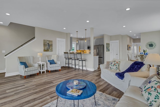 living room featuring baseboards, recessed lighting, and wood finished floors