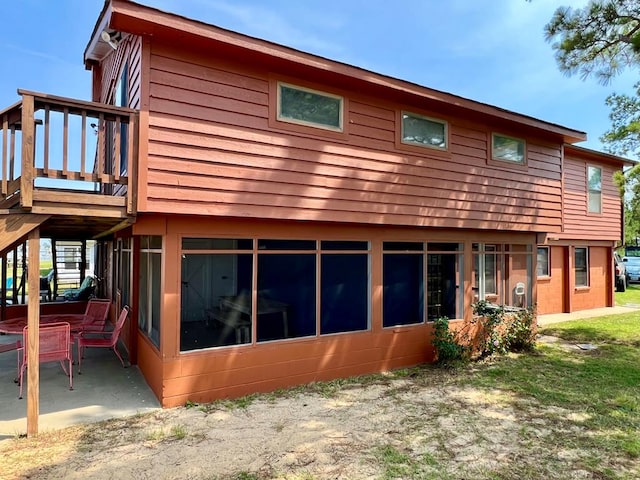 59 Judith Sound Cir, Lottsburg, VA 22511 - back of property featuring a wooden deck, a sunroom, stairway, and a patio area