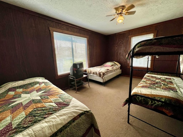 59 Judith Sound Cir, Lottsburg, VA 22511 - bedroom with carpet flooring, wood walls, a textured ceiling, and a ceiling fan