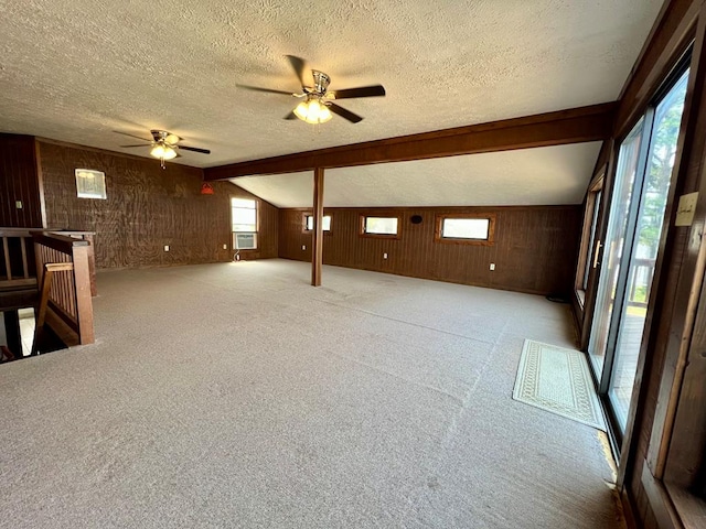 59 Judith Sound Cir, Lottsburg, VA 22511 - unfurnished living room featuring ceiling fan, a textured ceiling, wood walls, carpet flooring, and lofted ceiling