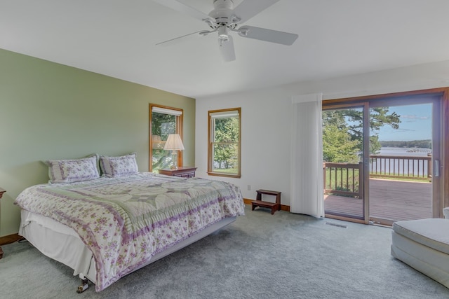 carpeted bedroom with ceiling fan, a water view, and access to outside