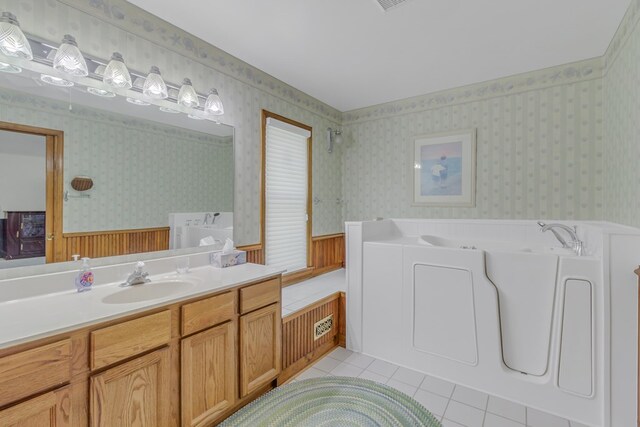 bathroom with a tub to relax in, tile patterned flooring, and vanity