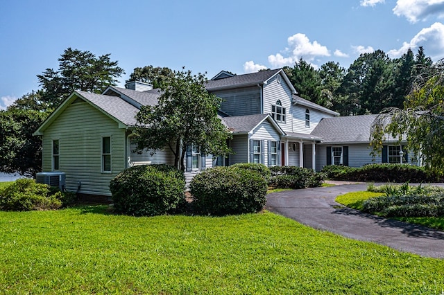 view of front of property featuring central air condition unit and a front yard