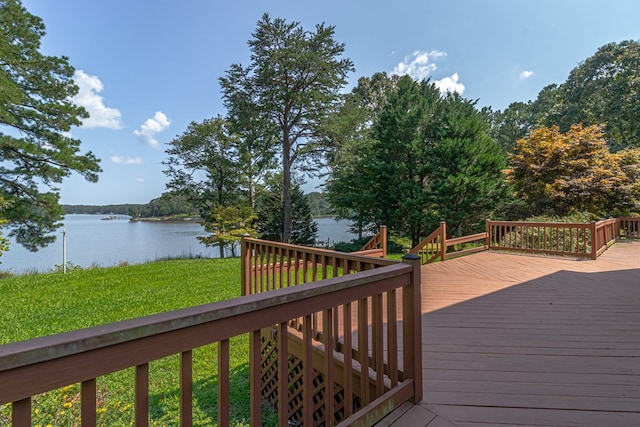 wooden terrace featuring a water view and a yard