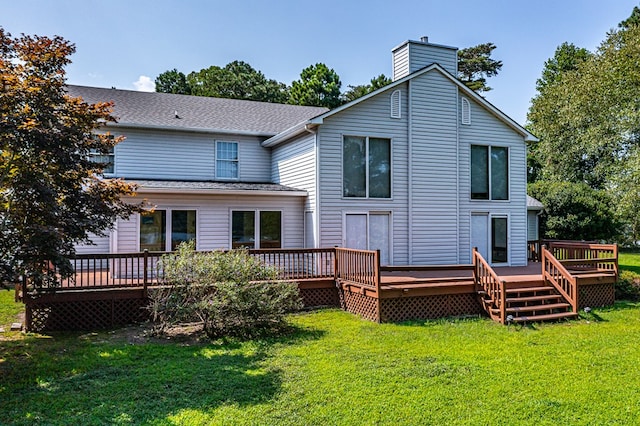 rear view of property with a deck and a yard