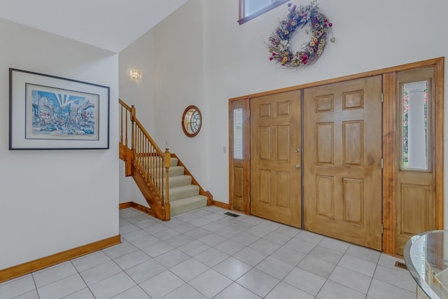 foyer featuring light tile patterned floors and a towering ceiling