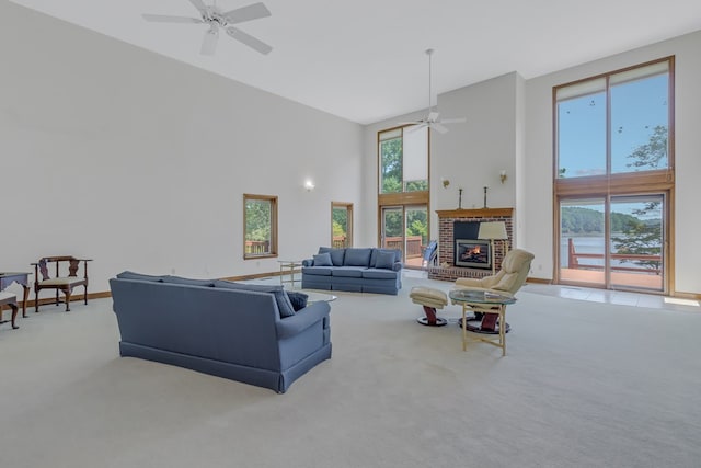 living room with a fireplace, ceiling fan, light carpet, and a high ceiling