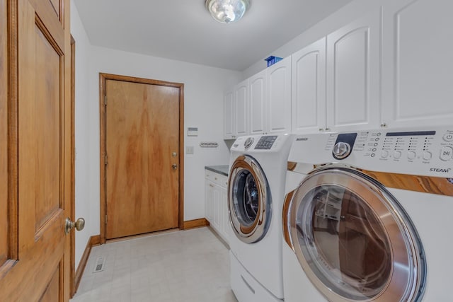 laundry area with washer and clothes dryer and cabinets