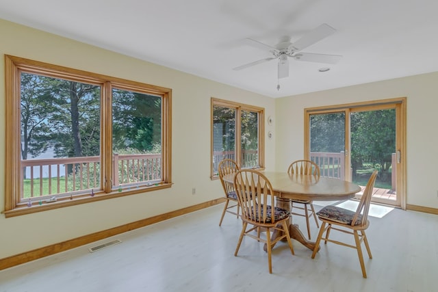 dining space with ceiling fan and light wood-type flooring