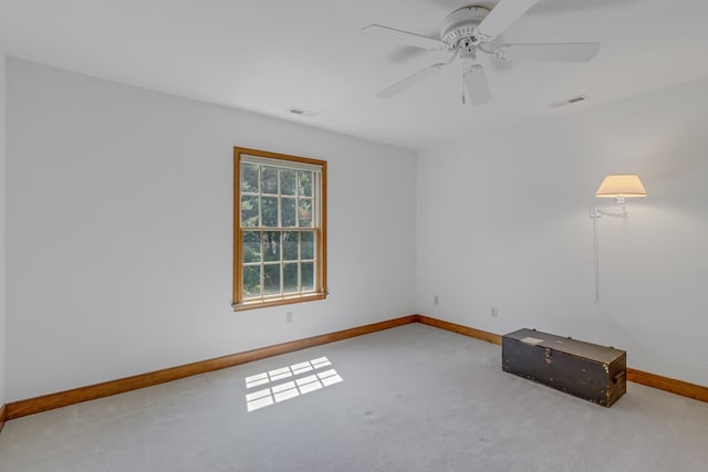 spare room with ceiling fan and light carpet