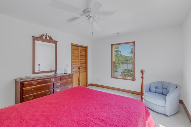 bedroom featuring ceiling fan, a closet, and light colored carpet