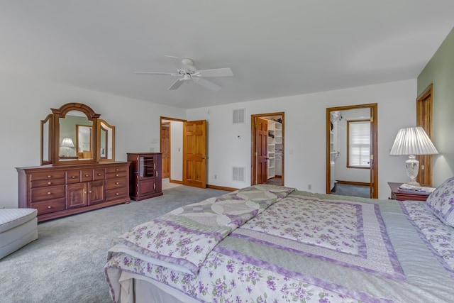 carpeted bedroom featuring ceiling fan, a spacious closet, and a closet