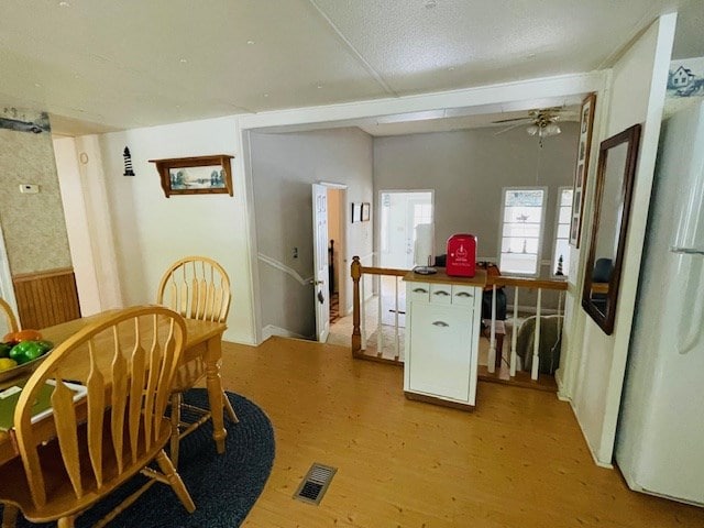 dining space featuring visible vents, a ceiling fan, and light wood finished floors