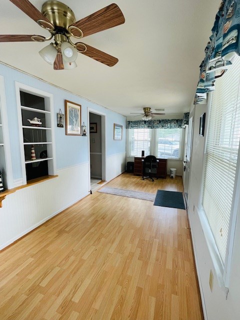 unfurnished sunroom with a ceiling fan