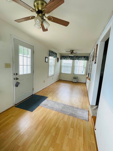 entryway with a ceiling fan, light wood-type flooring, and baseboards