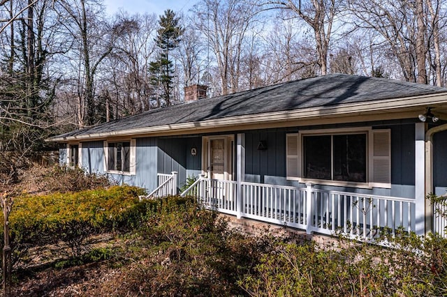 59 Hickory Rd, Lancaster, VA 22503 - view of front of house featuring a porch, a chimney, and roof with shingles