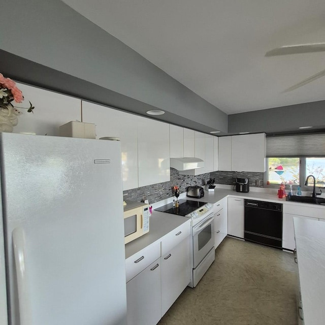 kitchen with tasteful backsplash, white appliances, white cabinets, and a sink