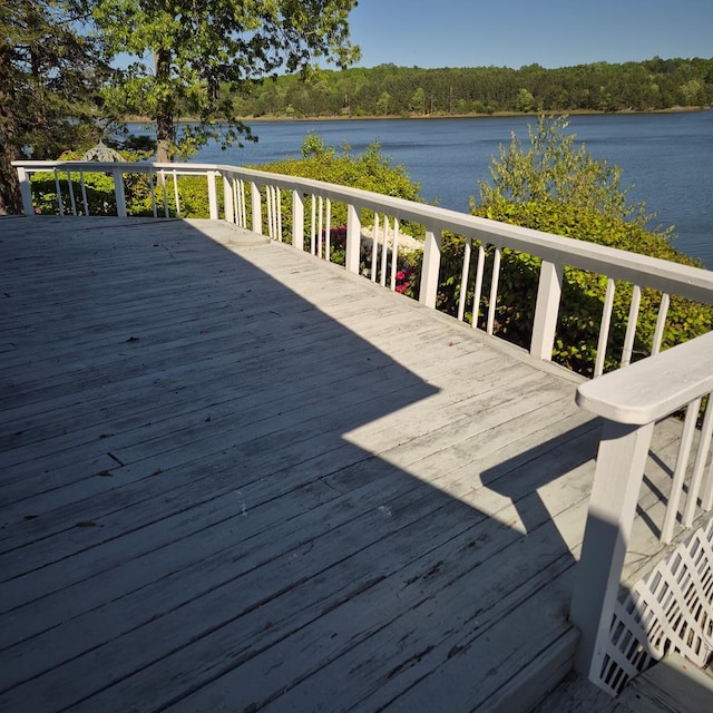 wooden terrace with a water view and a forest view