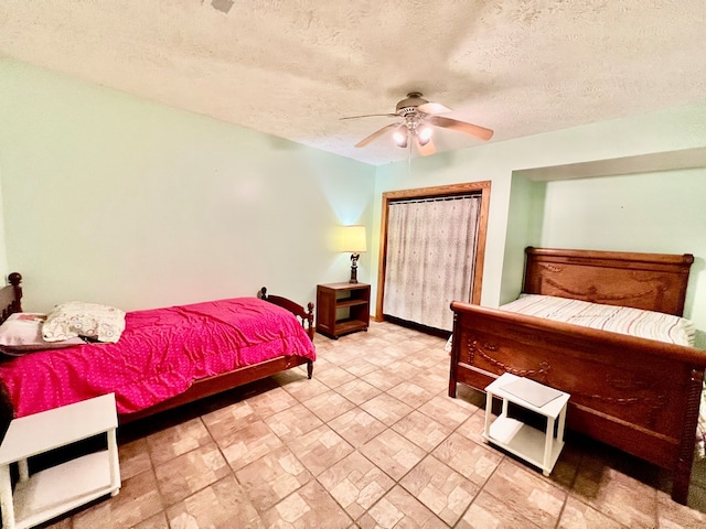 bedroom with ceiling fan and a textured ceiling