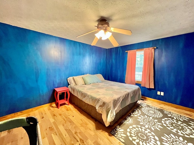 bedroom featuring ceiling fan, a textured ceiling, and light hardwood / wood-style flooring