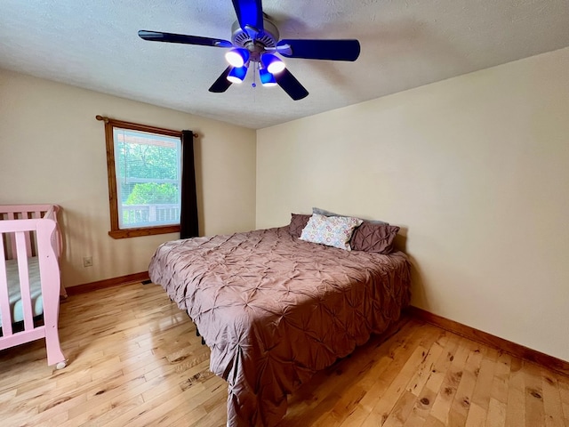 bedroom featuring a textured ceiling, light hardwood / wood-style floors, and ceiling fan