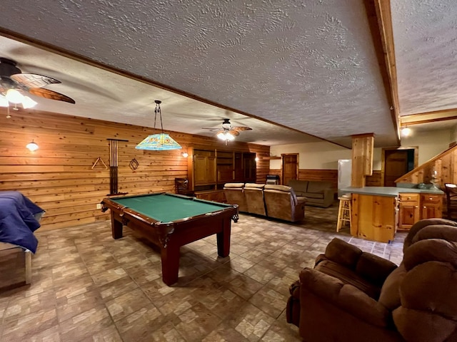 rec room featuring a textured ceiling, billiards, ceiling fan, and wood walls