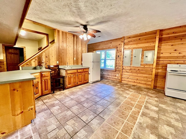 kitchen with electric panel, ceiling fan, white appliances, and wooden walls