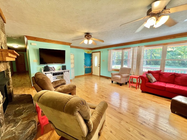 living room featuring crown molding, a fireplace, a textured ceiling, and light hardwood / wood-style flooring