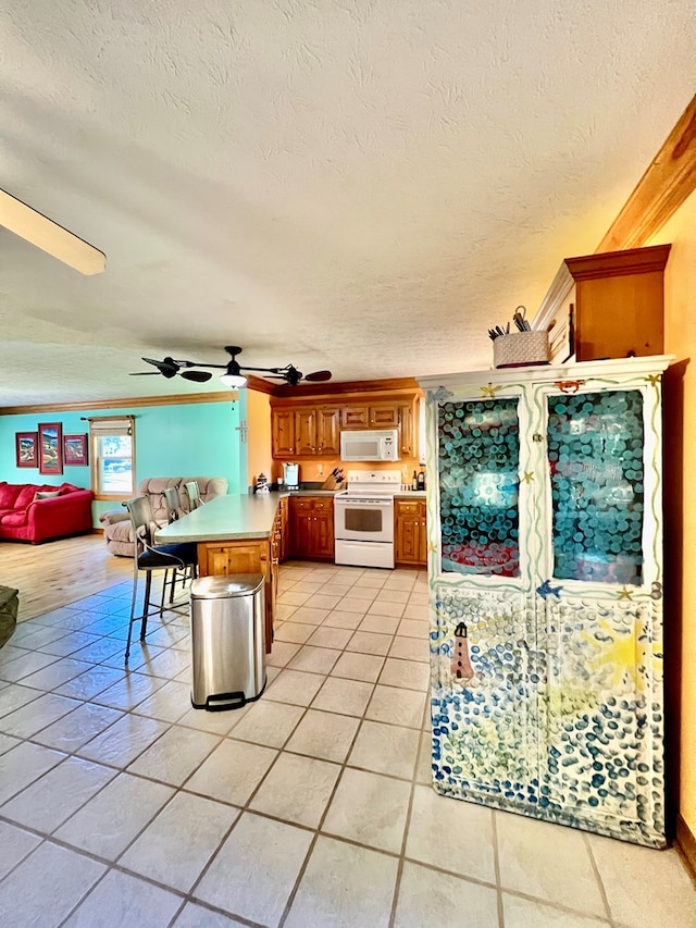 kitchen featuring white appliances, ceiling fan, a textured ceiling, light tile patterned flooring, and kitchen peninsula