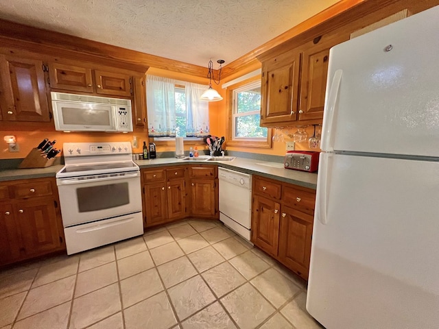 kitchen with sink, hanging light fixtures, a textured ceiling, white appliances, and light tile patterned floors