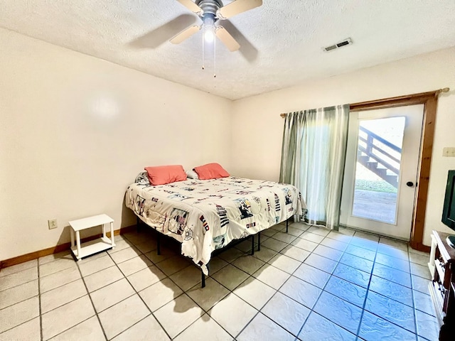 bedroom with ceiling fan, light tile patterned flooring, access to exterior, and a textured ceiling