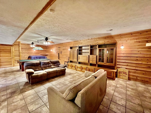 interior space featuring wooden walls, ceiling fan, and pool table