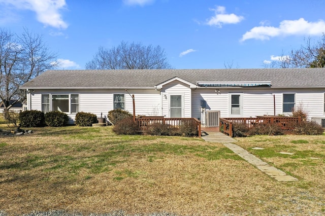 view of front of property featuring roof with shingles, a deck, and a front yard