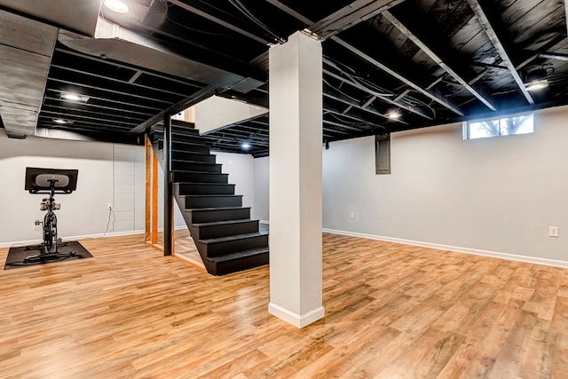 basement featuring stairway, baseboards, and wood finished floors