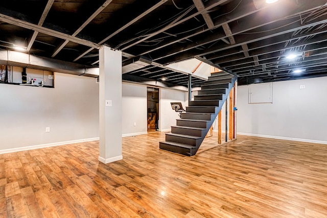 finished basement featuring wood finished floors, baseboards, and stairs